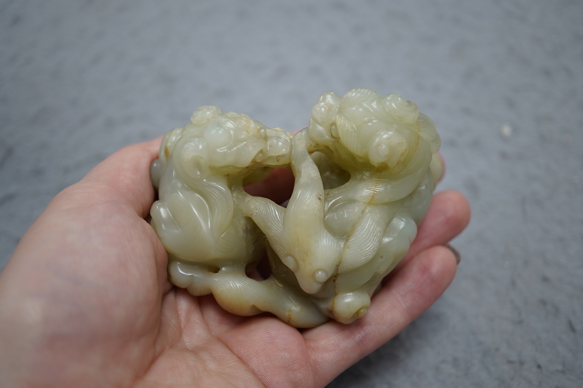 A Chinese celadon and russet jade group of two lion-dogs, 19th century